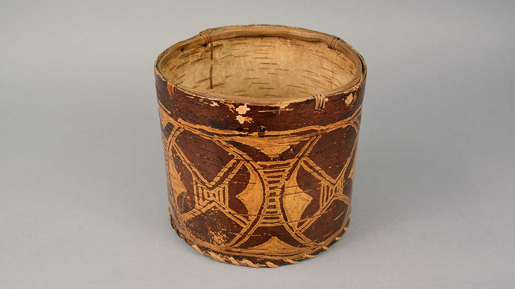 cylindrical solid basket with maroon and gold designs around the circumference
