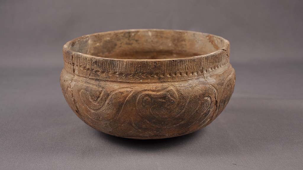 brown earthenware bowl with incised bird design