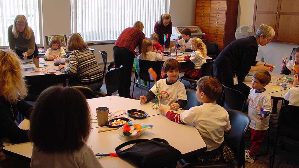 children and educators busily engaged in craft projects